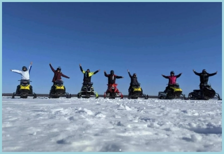 snowmobilers snowmobiling on lake and trails