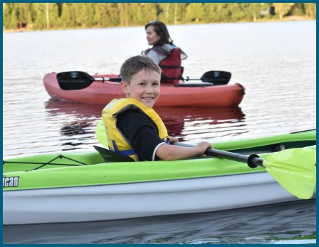 mom and son in kayaks on lake